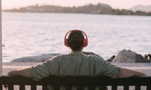 Portrait from the back of a young man in bright big headphones b